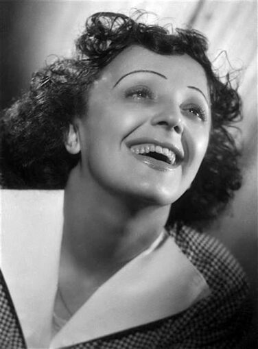 Joyful vintage portrait of a smiling woman looking upward, wearing a checkered coat with a wide white collar.