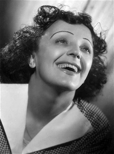 Joyful vintage portrait of a smiling woman looking upward, wearing a checkered coat with a wide white collar.