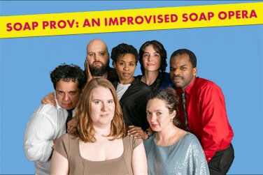 Group of eight diverse performers posing together in front of a blue backdrop, with a yellow banner reading 'SOAP PROV: AN IMPROVISED SOAP OPERA'