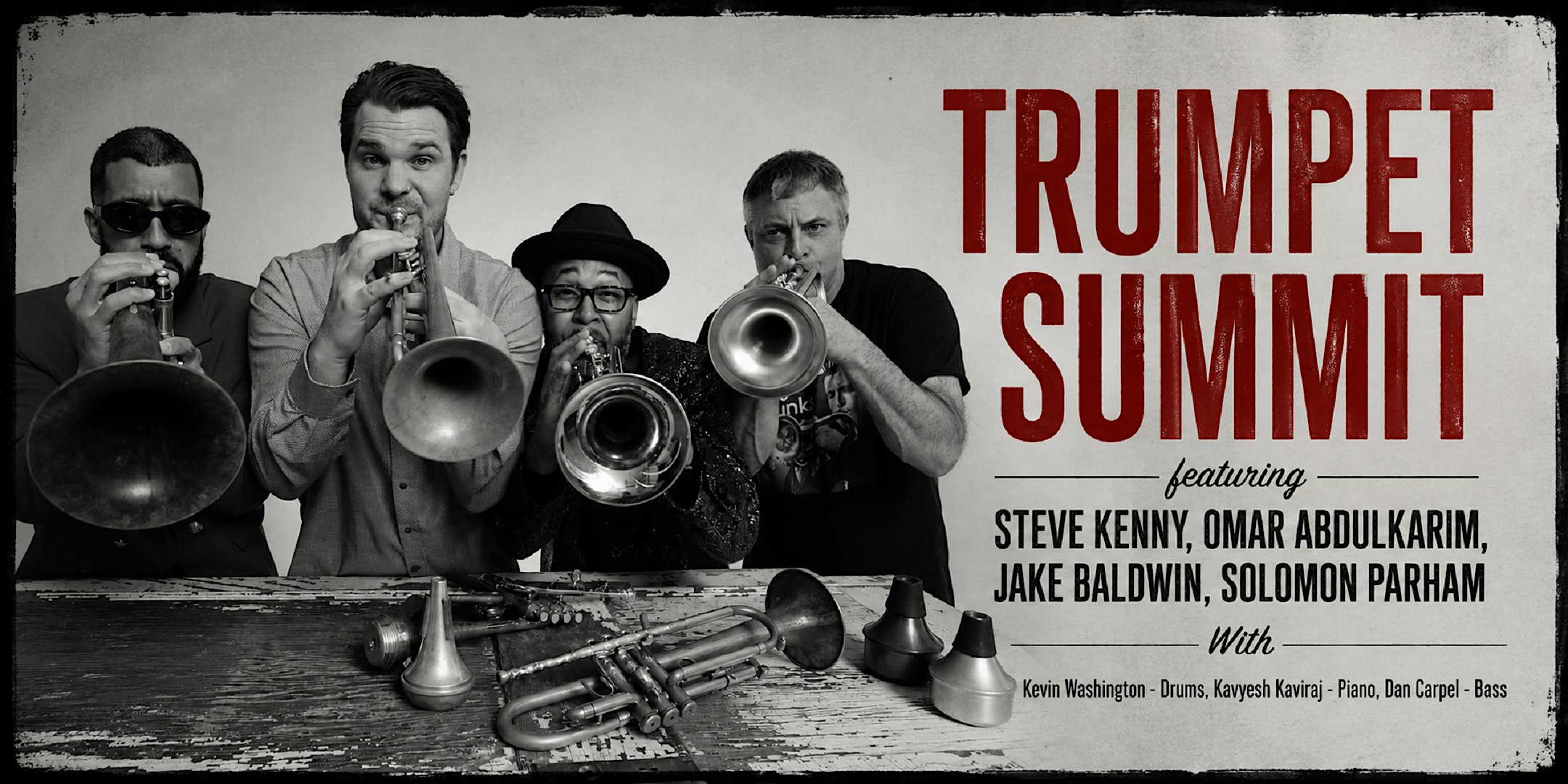 Group of brass players posing with trumpets and trombones beside a bold red 'Trumpet Summit' poster on a vintage-looking banner.