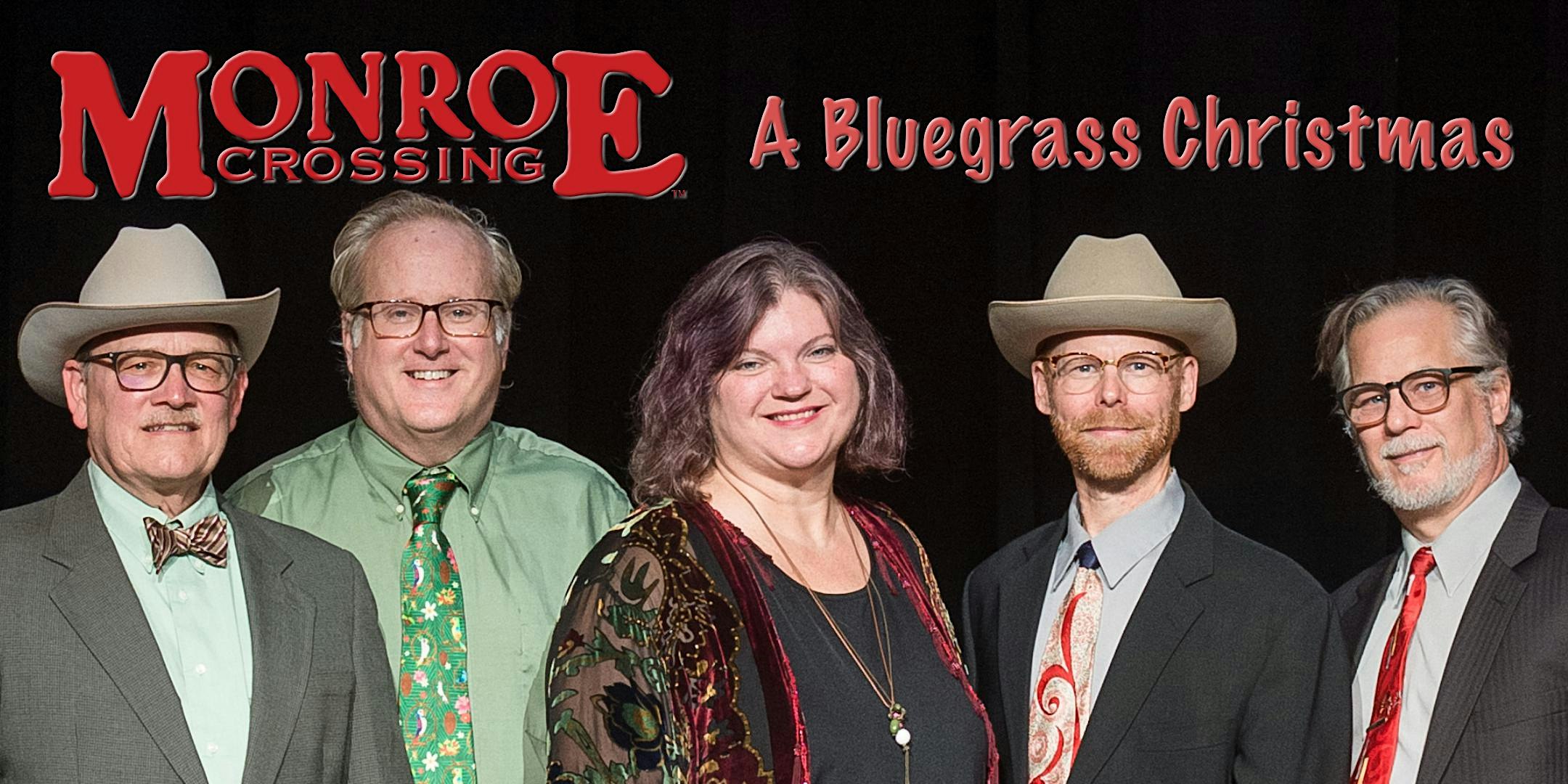 Group photo of five musicians on stage for Monroe Crossing's A Bluegrass Christmas, dressed in suits and dresses with a dark backdrop and red title above them.
